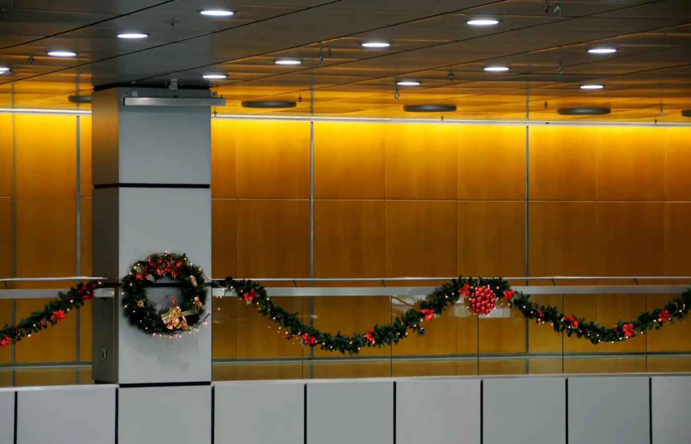 Décorations de Noël avec des guirlandes et des couronnes lumineuses dans un environnement d’entreprise moderne et professionnel.