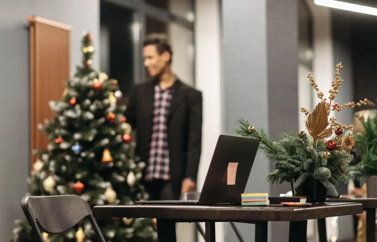 Bureau moderne décoré pour Noël, avec un sapin et des ornements festifs, créant une atmosphère conviviale et professionnelle.